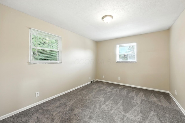 4972 Woodbriar Pl, Columbus, OH 43229 - empty room featuring dark carpet and a textured ceiling