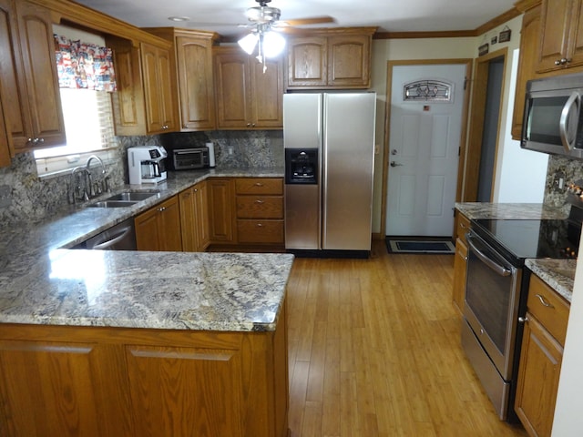 1766 Thrailkill Rd, Grove City, OH 43123 - kitchen with stainless steel appliances, brown cabinets, a ceiling fan, light stone countertops, and ornamental molding