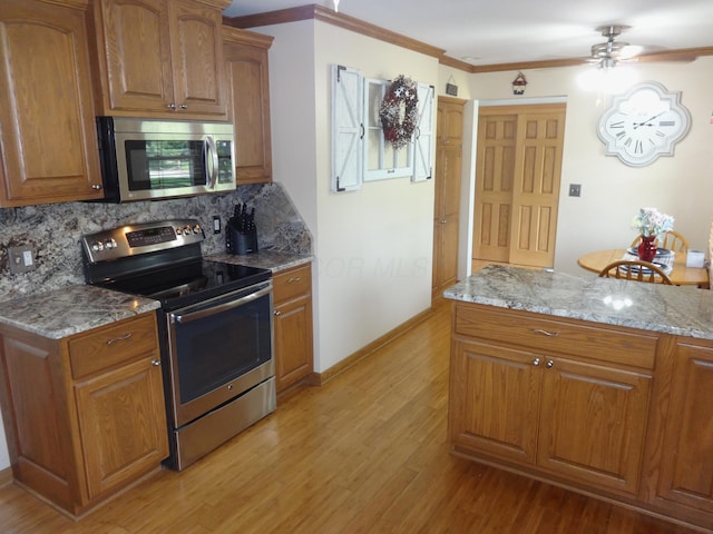 1766 Thrailkill Rd, Grove City, OH 43123 - kitchen featuring stainless steel appliances, ceiling fan, ornamental molding, decorative backsplash, and light wood-style floors