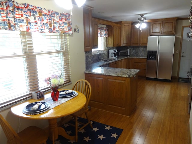 1766 Thrailkill Rd, Grove City, OH 43123 - kitchen with stainless steel fridge with ice dispenser, a ceiling fan, a peninsula, brown cabinets, and decorative backsplash