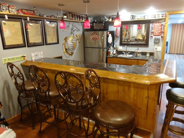 1766 Thrailkill Rd, Grove City, OH 43123 - indoor wet bar featuring freestanding refrigerator, wood finished floors, and decorative light fixtures