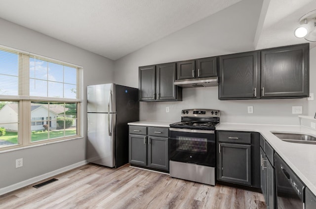 5727 Sundial Dr, Galloway, OH 43119 - kitchen featuring stainless steel appliances, vaulted ceiling, under cabinet range hood, light wood-type flooring, and light countertops