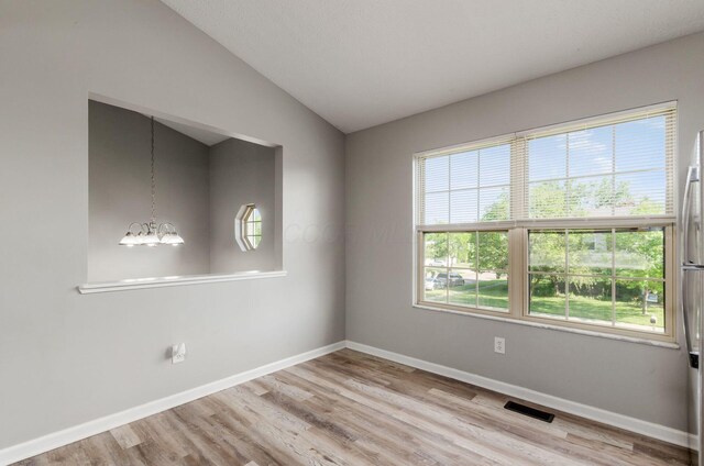 5727 Sundial Dr, Galloway, OH 43119 - unfurnished room featuring wood finished floors, a chandelier, and lofted ceiling