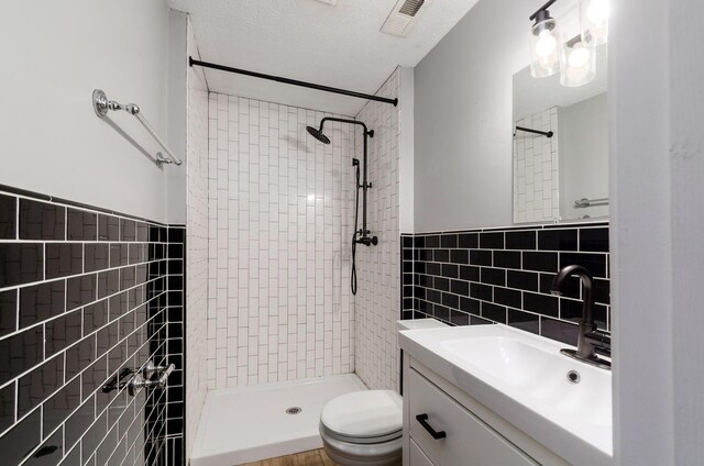 5727 Sundial Dr, Galloway, OH 43119 - full bath featuring tile walls, a shower stall, vanity, a wainscoted wall, and a textured ceiling