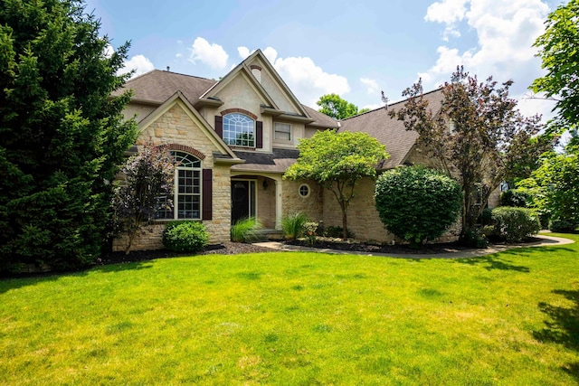 2567 Carmel Dr, Lewis Center, OH 43035 - view of front facade featuring stone siding, a front yard, stucco siding, and a shingled roof