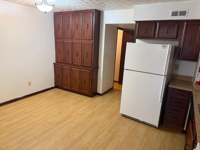 5600 Cartwright Ln Unit 19, Columbus, OH 43231 - kitchen featuring freestanding refrigerator, light wood-style floors, and a textured ceiling