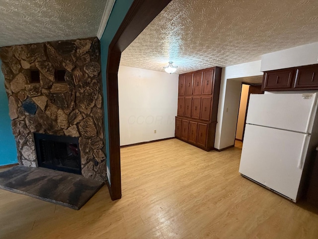 5600 Cartwright Ln Unit 19, Columbus, OH 43231 - unfurnished living room with a textured ceiling, light wood-type flooring, and a fireplace
