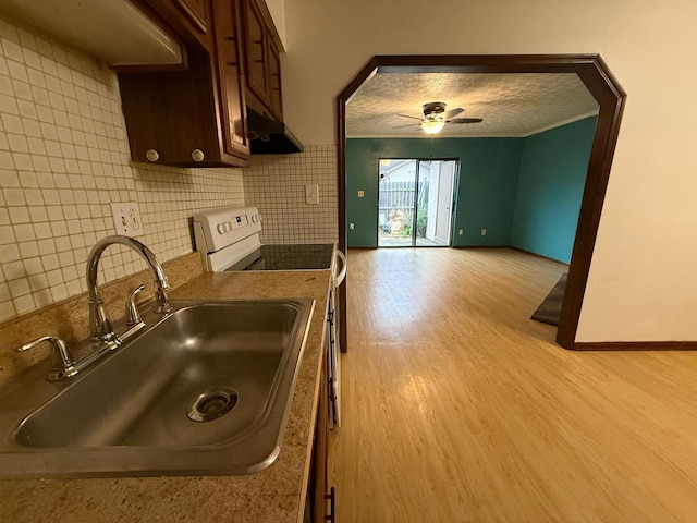 5600 Cartwright Ln Unit 19, Columbus, OH 43231 - kitchen with electric range, light wood-style floors, ceiling fan, dark brown cabinets, and backsplash