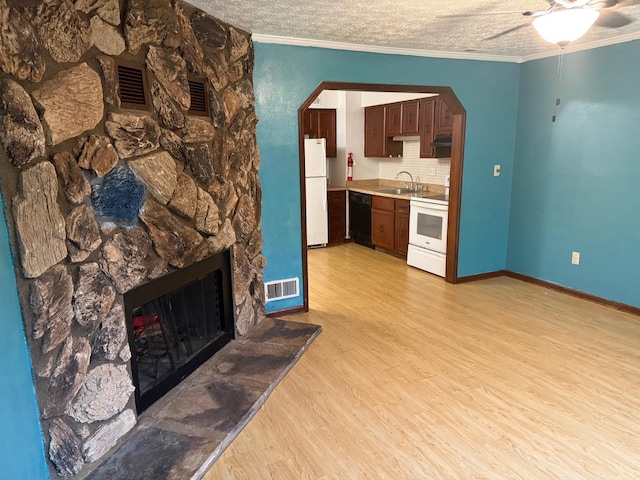 5600 Cartwright Ln Unit 19, Columbus, OH 43231 - living room featuring light wood-style flooring, a ceiling fan, a stone fireplace, arched walkways, and crown molding
