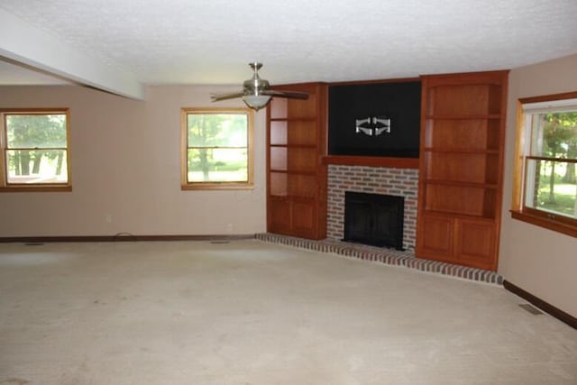 6781 Thoreau Ln NE, Baltimore, OH 43105 - unfurnished living room featuring a textured ceiling, carpet floors, ceiling fan, and a brick fireplace