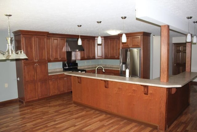6781 Thoreau Ln NE, Baltimore, OH 43105 - kitchen featuring stainless steel appliances, wall chimney exhaust hood, brown cabinetry, a textured ceiling, and dark wood-style flooring