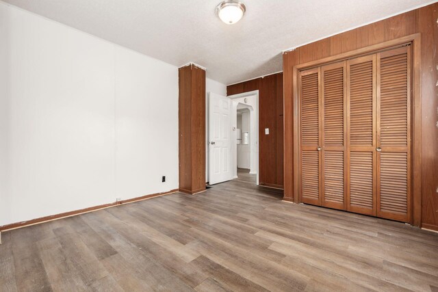 1680 Linwood Ave, Columbus, OH 43207 - unfurnished bedroom with wood finished floors, a closet, and wooden walls