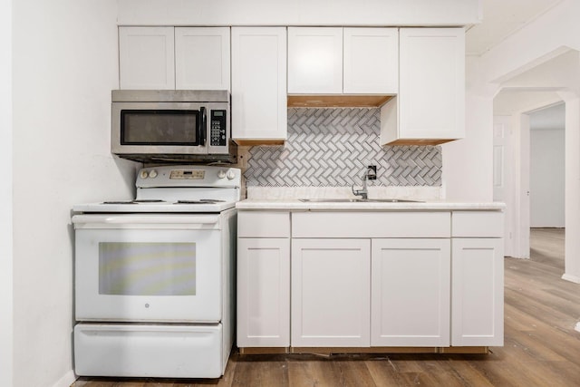 1680 Linwood Ave, Columbus, OH 43207 - kitchen with white electric range, stainless steel microwave, tasteful backsplash, light countertops, and white cabinets