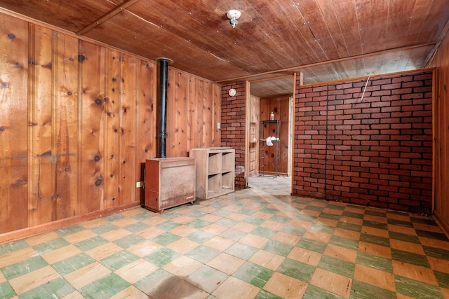 1680 Linwood Ave, Columbus, OH 43207 - empty room featuring wood ceiling, brick wall, tile patterned floors, wooden walls, and a wood stove