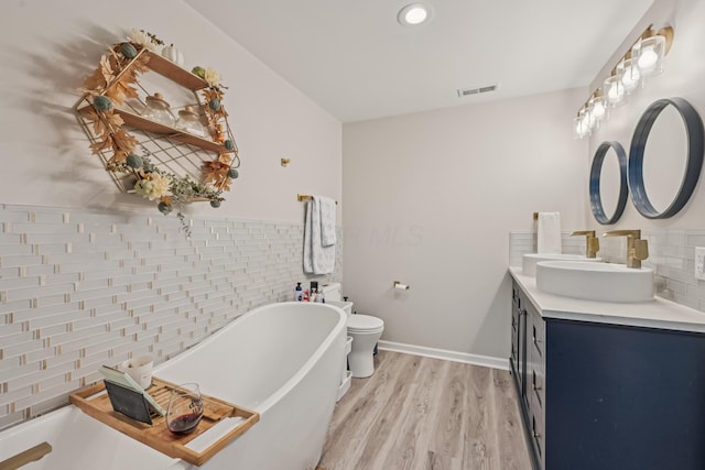15586 Stump Run, Laurelville, OH 43135 - bathroom featuring a freestanding bath, double vanity, wood finished floors, tile walls, and recessed lighting