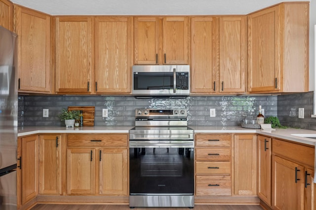 6872 Spring Bloom Dr, Canal Winchester, OH 43110 - kitchen featuring appliances with stainless steel finishes, light countertops, backsplash, and wood finished floors