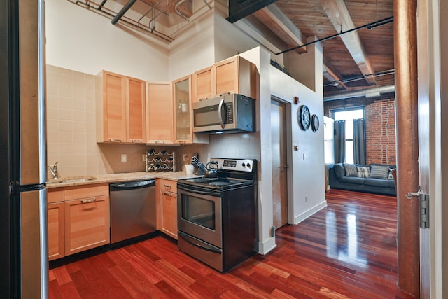 150 E Main St Unit 207, Columbus, OH 43215 - kitchen with stainless steel appliances, dark wood-style floors, light brown cabinetry, decorative backsplash, and a wooden ceiling with exposed beams