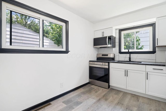 536 Pierce Ave, Columbus, OH 43213 - kitchen featuring stainless steel appliances, healthy amount of natural light, light wood finished floors, and decorative backsplash