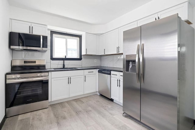 536 Pierce Ave, Columbus, OH 43213 - kitchen with stainless steel appliances, dark countertops, white cabinets, and light wood-type flooring