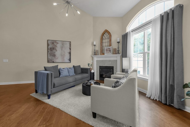 6277 Hudson Reserve Way, Westerville, OH 43081 - living room featuring wood finished floors, plenty of natural light, a glass covered fireplace, and a chandelier