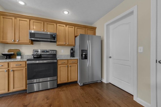 6277 Hudson Reserve Way, Westerville, OH 43081 - kitchen featuring appliances with stainless steel finishes, dark wood-style flooring, light stone counters, brown cabinetry, and recessed lighting