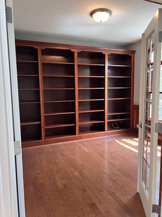 8730 Swisher Creek Xing, New Albany, OH 43054 - empty room featuring wood finished floors, a textured ceiling, a sauna / steam room, and french doors