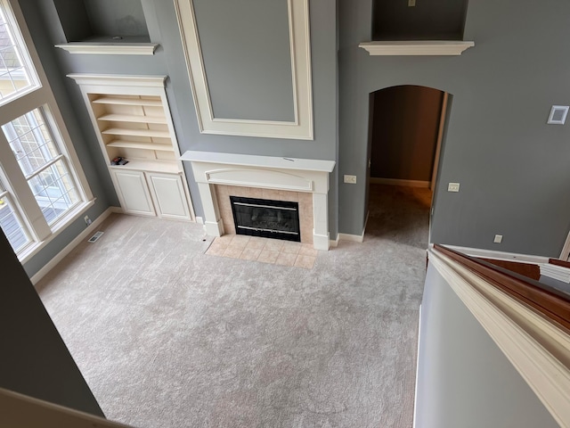 8730 Swisher Creek Xing, New Albany, OH 43054 - unfurnished living room featuring a fireplace, arched walkways, carpet, and built in features