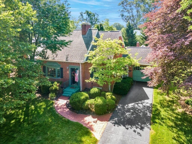1855 Suffolk Rd, Columbus, OH 43221 - view of front of house with a chimney, concrete driveway, roof with shingles, brick siding, and a garage