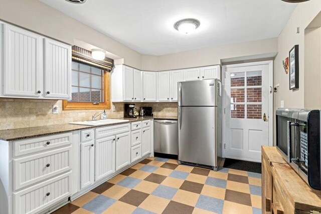 1855 Suffolk Rd, Columbus, OH 43221 - kitchen featuring stainless steel appliances, light flooring, decorative backsplash, white cabinets, and dark stone counters