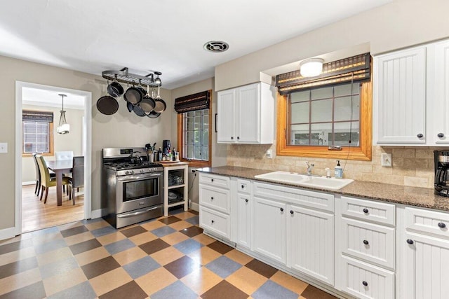 1855 Suffolk Rd, Columbus, OH 43221 - kitchen with stainless steel gas range oven, light floors, decorative backsplash, and white cabinetry