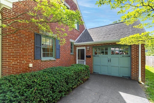 1855 Suffolk Rd, Columbus, OH 43221 - view of front of home with an attached garage, asphalt driveway, and brick siding