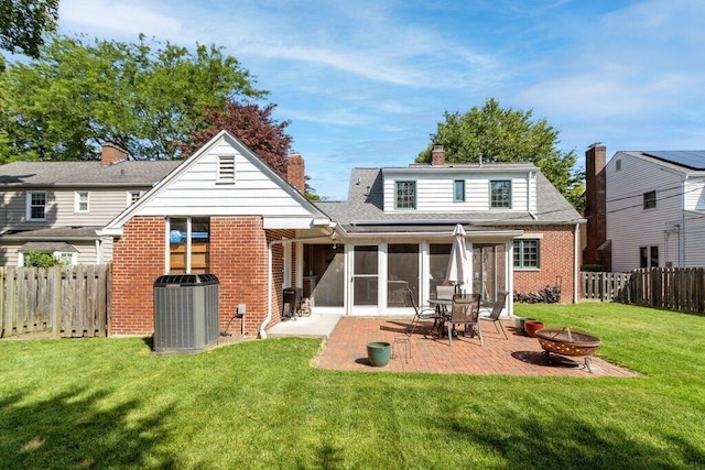1855 Suffolk Rd, Columbus, OH 43221 - back of property featuring brick siding, an outdoor fire pit, a fenced backyard, a patio area, and a sunroom