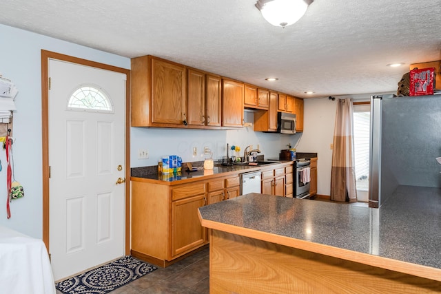 508 Carolyn Rd, Washington Court House, OH 43160 - kitchen with appliances with stainless steel finishes, dark countertops, a textured ceiling, brown cabinets, and recessed lighting
