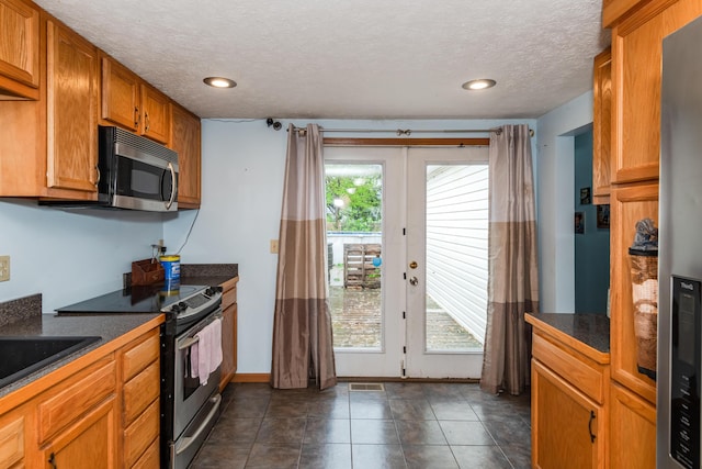 508 Carolyn Rd, Washington Court House, OH 43160 - kitchen with appliances with stainless steel finishes, dark countertops, french doors, brown cabinets, and a textured ceiling