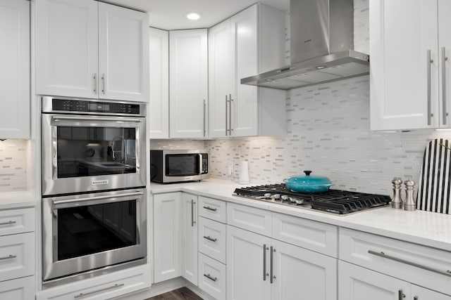50 S Kellner Rd, Columbus, OH 43209 - kitchen with wall chimney exhaust hood, appliances with stainless steel finishes, white cabinets, and tasteful backsplash
