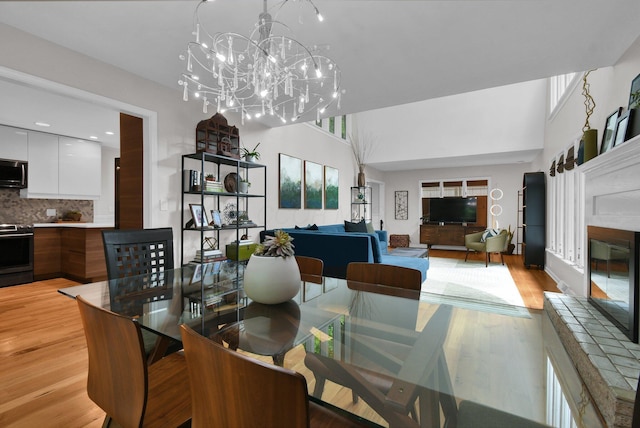 160 Wildwood Dr, Granville, OH 43023 - dining space featuring light wood finished floors, a chandelier, and a glass covered fireplace