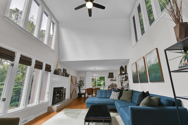 160 Wildwood Dr, Granville, OH 43023 - living room with a towering ceiling, light wood-type flooring, a ceiling fan, a glass covered fireplace, and a chandelier