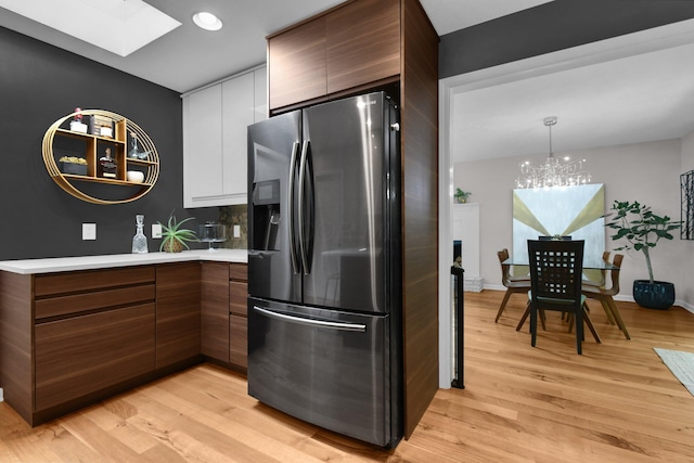 160 Wildwood Dr, Granville, OH 43023 - kitchen featuring stainless steel fridge with ice dispenser, a skylight, modern cabinets, light countertops, and light wood-type flooring