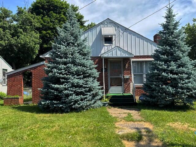 498 E Mark St, Marion, OH 43302 - view of front of house with board and batten siding, brick siding, and a front lawn