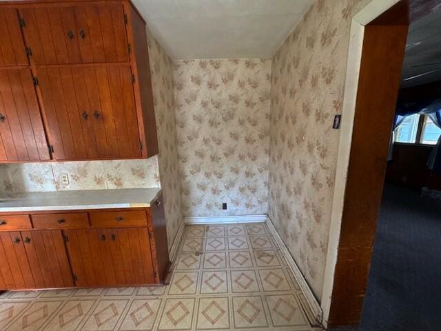 498 E Mark St, Marion, OH 43302 - kitchen with wallpapered walls, light countertops, brown cabinetry, and light floors