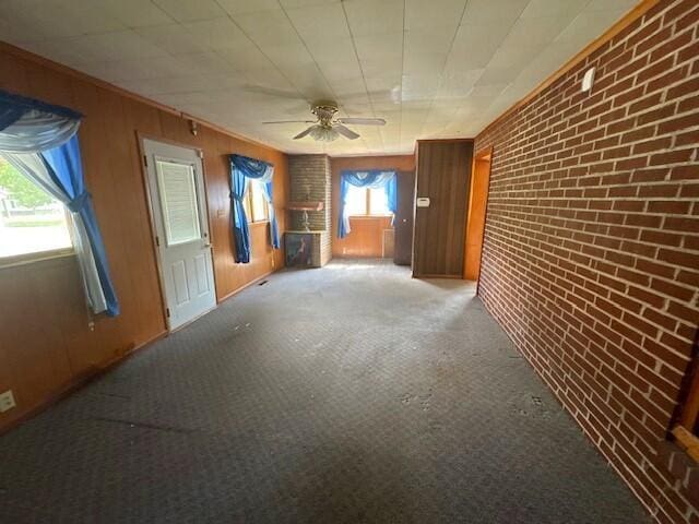 498 E Mark St, Marion, OH 43302 - unfurnished room with brick wall, carpet flooring, a ceiling fan, and wood walls