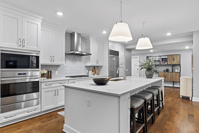 105 N Riverview St Unit 218, Dublin, OH 43017 - kitchen with wall chimney range hood, built in appliances, dark wood-type flooring, a kitchen breakfast bar, and tasteful backsplash