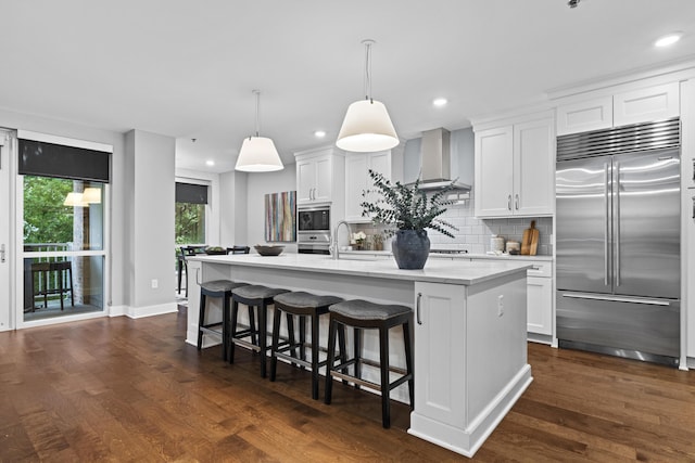105 N Riverview St Unit 218, Dublin, OH 43017 - kitchen with built in appliances, light countertops, a center island with sink, white cabinets, and recessed lighting