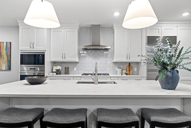 105 N Riverview St Unit 218, Dublin, OH 43017 - kitchen featuring wall chimney exhaust hood, built in appliances, decorative backsplash, pendant lighting, and white cabinets