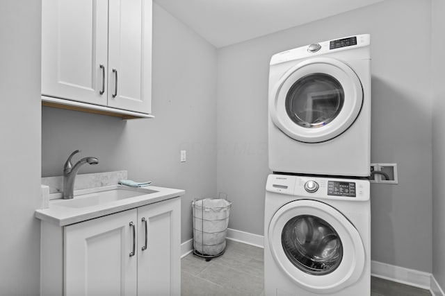 105 N Riverview St Unit 218, Dublin, OH 43017 - laundry area featuring stacked washer / dryer, cabinet space, and light tile patterned flooring