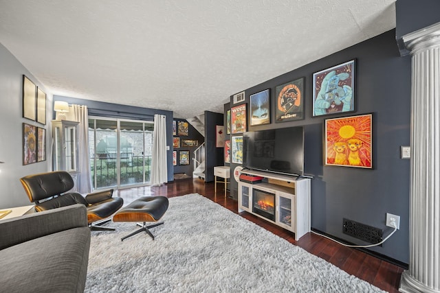 1208 Ashland Ave, Columbus, OH 43212 - living room with a textured ceiling, wood finished floors, and decorative columns