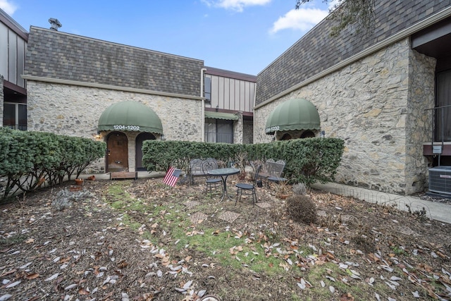 1208 Ashland Ave, Columbus, OH 43212 - rear view of house with stone siding, mansard roof, and roof with shingles