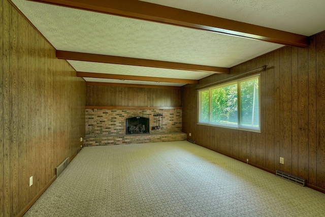 8899 Chevington Ct, Pickerington, OH 43147 - unfurnished living room with beamed ceiling, wooden walls, a fireplace, carpet floors, and a textured ceiling