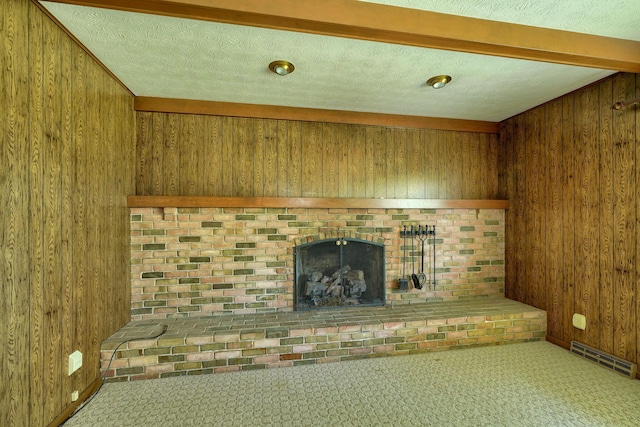 8899 Chevington Ct, Pickerington, OH 43147 - unfurnished living room with wood walls, a fireplace, a textured ceiling, and carpet flooring