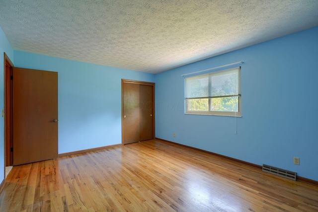 8899 Chevington Ct, Pickerington, OH 43147 - unfurnished bedroom featuring a closet, wood finished floors, and a textured ceiling